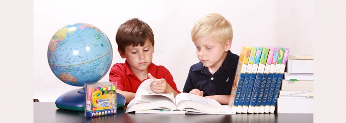 Dos nens fullejant un llibre