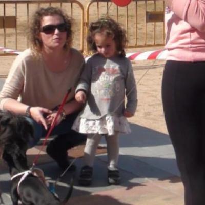 Una nena mira un gos davant de Can Gruart aquest dissabte 5 d'abril.